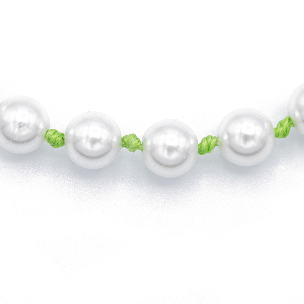 Pearl necklace with green knotted cording on a white background