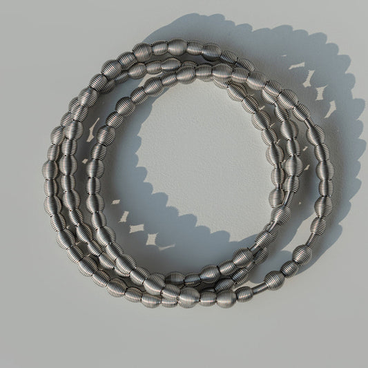 Silver all beaded dia bracelets on a light gray background