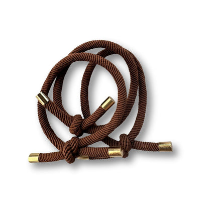 Brown Hairtie with gold metal tips on a white background