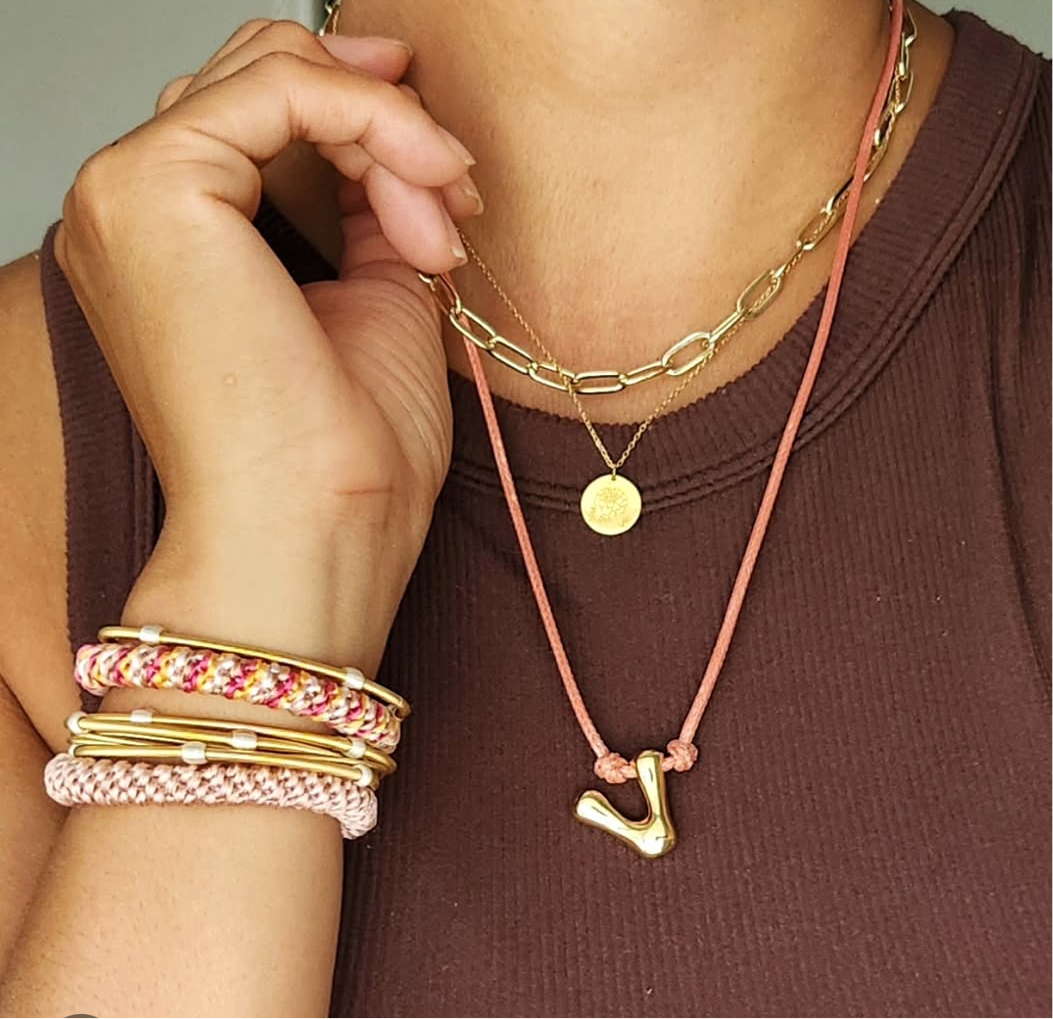 Woman wearing DIA bracelets and 2 hair ties on her wrist. 