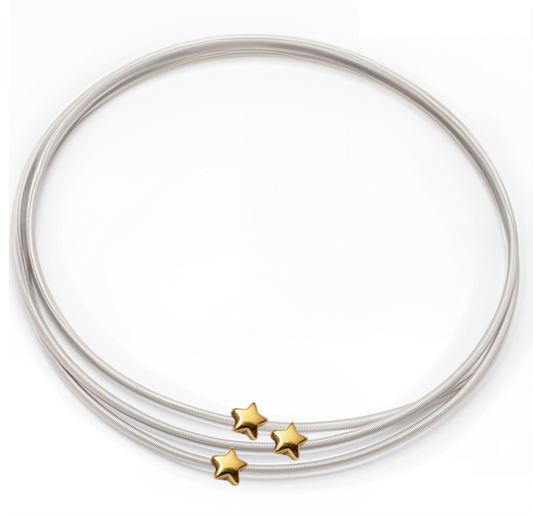 Silver bangles with gold star accents on a white background