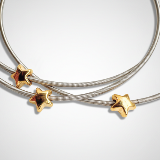 DIA Bracelets with gold star-shaped clasps on a light gray background