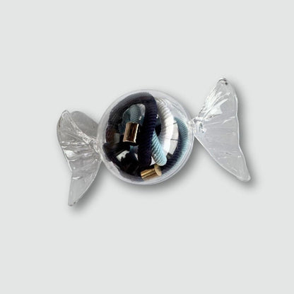 Decorative candy with hair ties in it on a light gray background