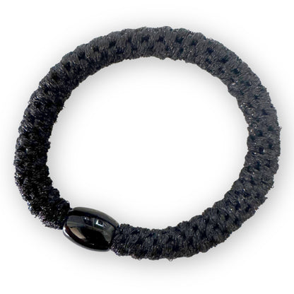 Black braided hair tie on a white background
