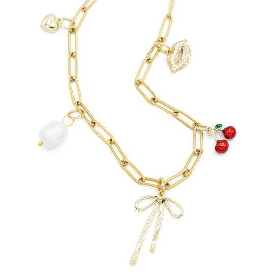 Spaced charm necklace on paperclip chain with bow, cherries, kiss, pearl, and heart charms.