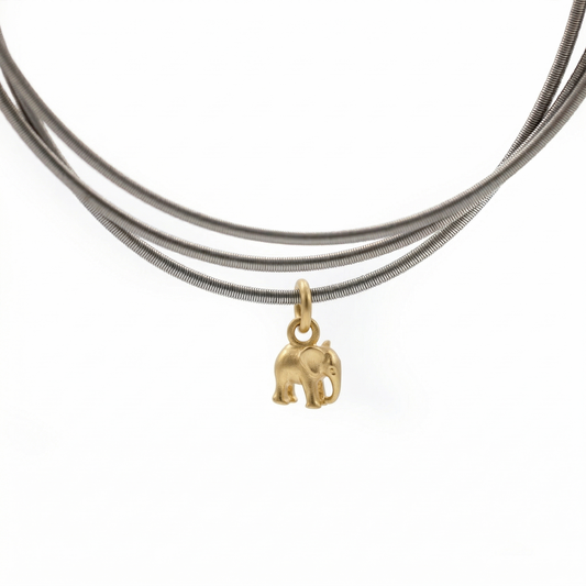 Gold elephant pendant on a silver DIA bracelets against a white background