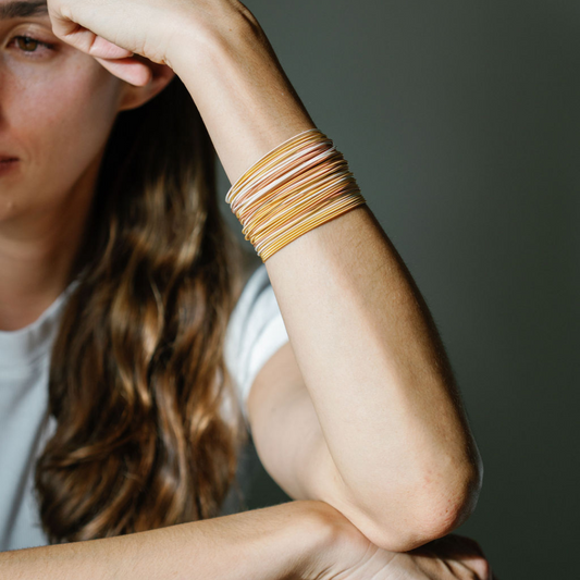 Model Wearing set of 50 Warm Mixed Metal Dia Bracelets