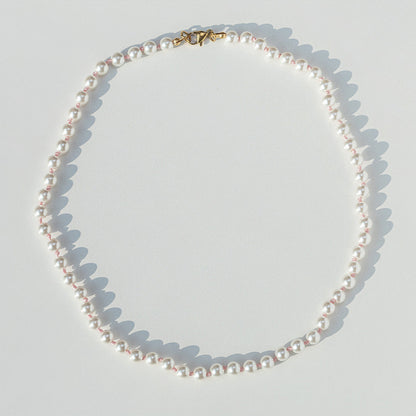 Pearl necklace on a light gray background
