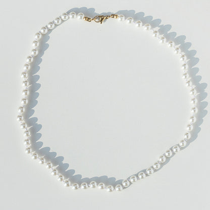 white hand knotted Pearl necklace on a light gray background